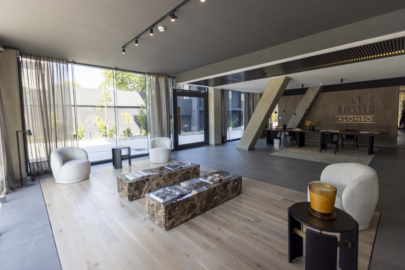 Hall de acceso del edificio con lounge y branding At Home Alonso